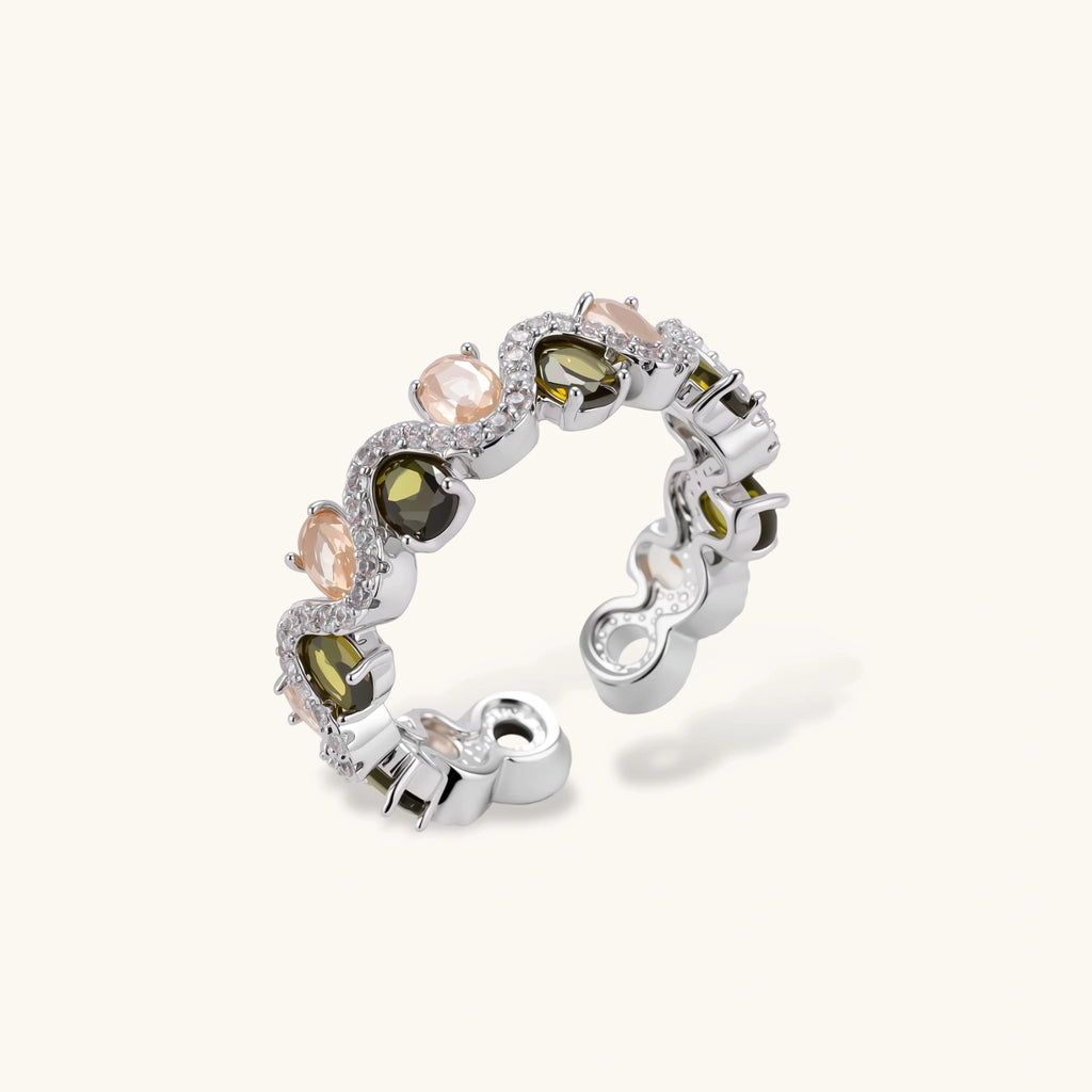 Adjustable copper ring with platinum plating, featuring alternating peach and green zirconia stones in organic wave pattern