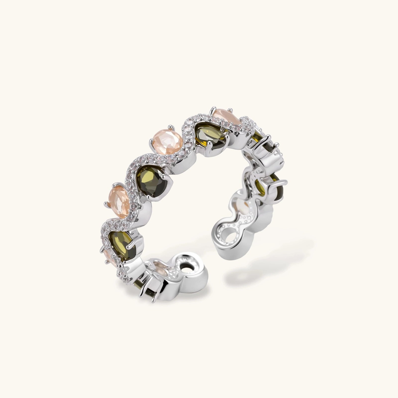 Adjustable copper ring with platinum plating, featuring alternating peach and green zirconia stones in organic wave pattern